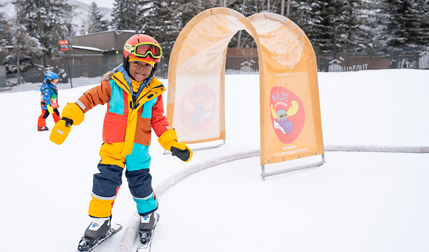 Little boy smiles as he skies through the Panda Peak Childs area at Buttermilk